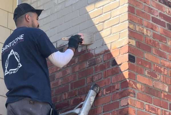 Brushing limewash on exterior house brick