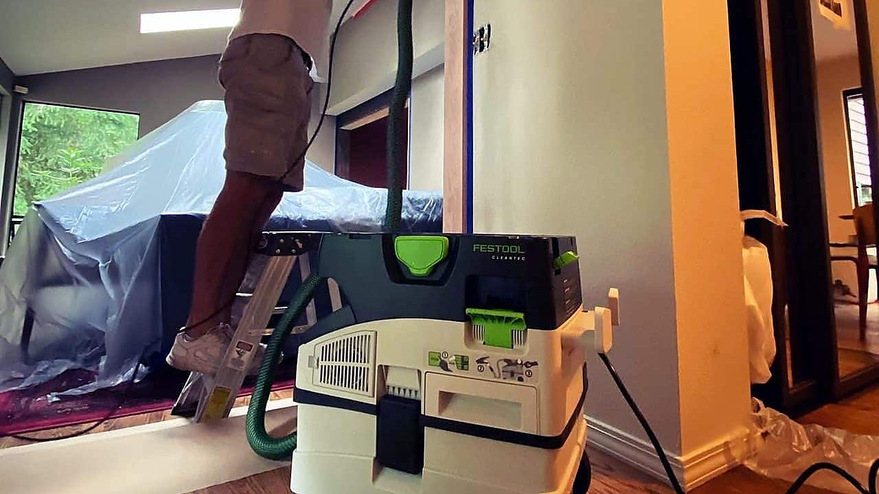 Sanding with a dust extractor while furniture stays covered in the next room